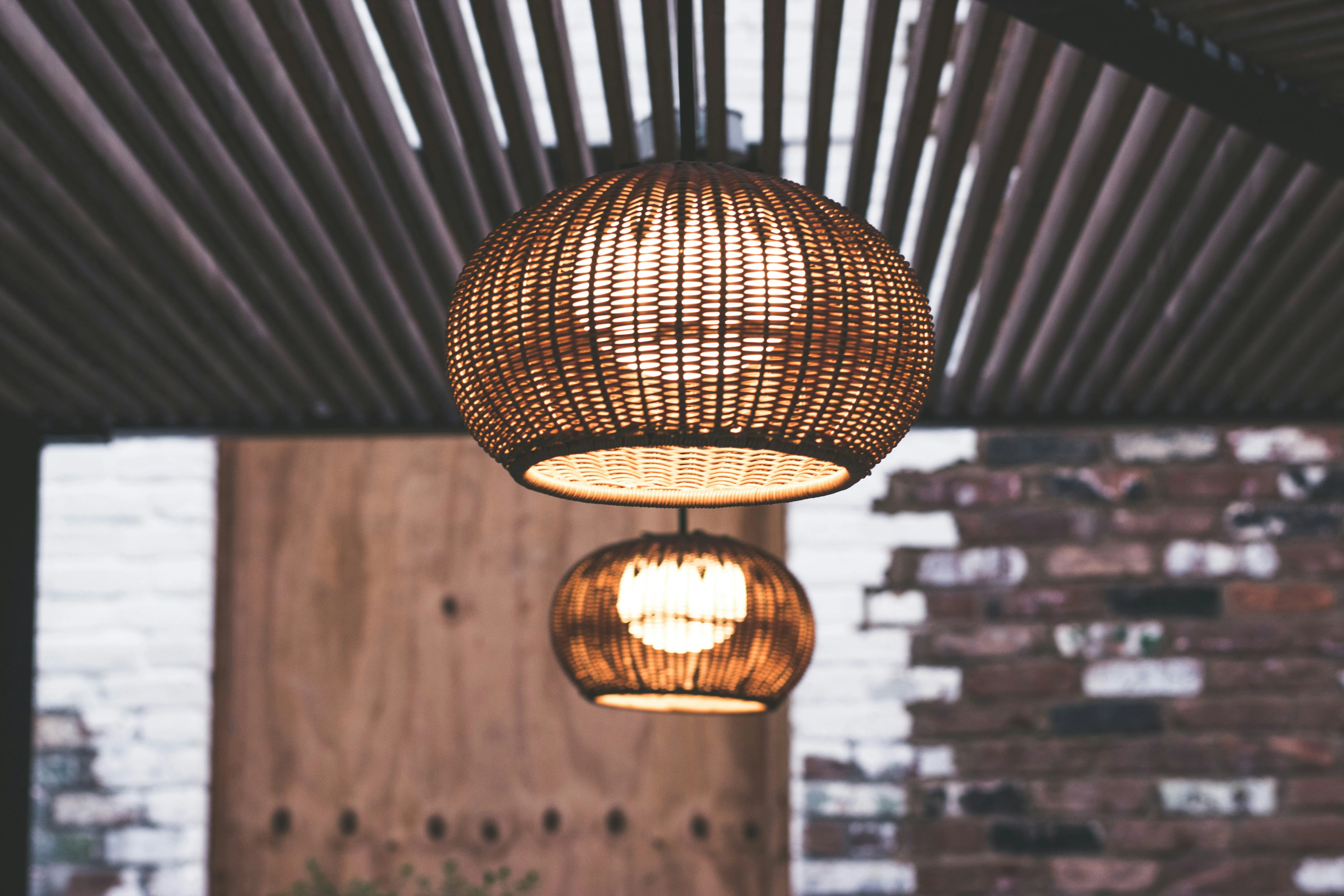 Wicker pendant lamp with warm ambient glow in a rustic venue setting