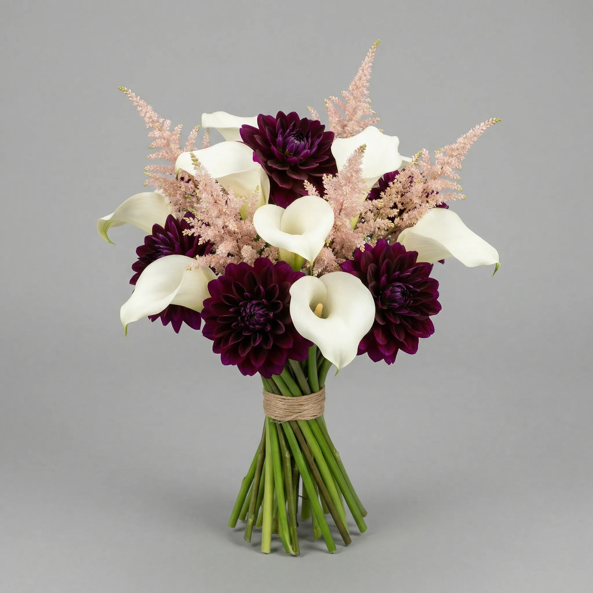 Modern hand-tied bridal bouquet with white calla lilies, blush astilbe, and deep plum dahlias, studio lighting on seamless gray background